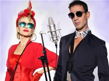 Das Duo Schwarzblond bietet Gesang, Musik und Kabarett und hat sich vor einem  Mikrofon aufgestellt. Das Duo ist im Theater im Fischereihafen zu Gast. 