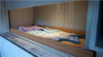 Das Fenster der Babyklappe ist geöffnet, Baby-Schlafsack, Handtuch, Decken liegen bereit.
