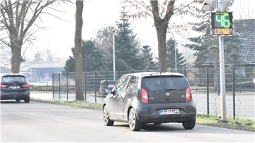 Zwei Autos auf einer Straße vor einem Geschwindigkeitsmessgerät.