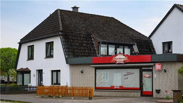 Ein Mann steht in einem Badezimmer am Fenster.
