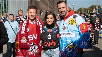 Drei Menschen in Eishockey-Trikots. 