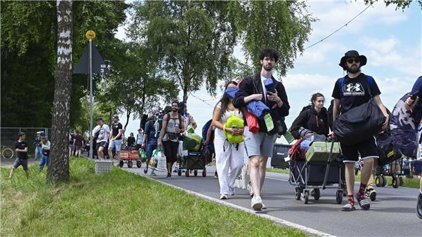 Ein Menschenmenge auf der Straße mit Rucksäcken und Bollerwagen