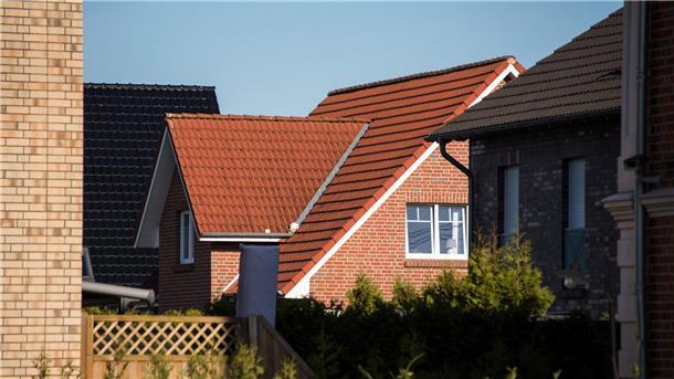 Ein Wohnhaus steht in einem Neubaugebiet. 