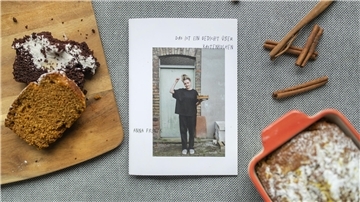 Das Backbuch "Das ist ein Gedicht über Kastenkuchen" zwischen zwei Kastenkuchen und Zimtstangen-Deko. 