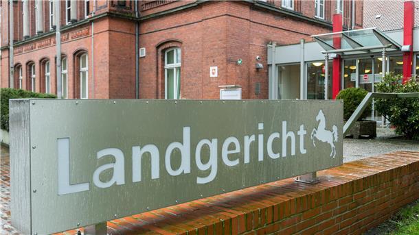 Ein Schild mit der Aufschrift Landgericht Verden steht vor einem Gebäude. 