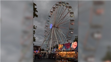 Ein Riesenrad leicht auf einem Festplatz.