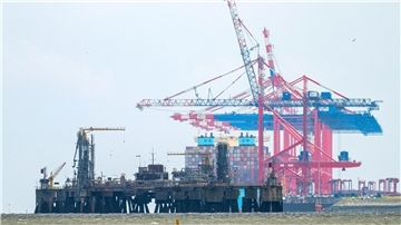Die Baustelle für einen Anleger, der für ein zweites LNG-Terminal benötigt wird. Im Hintergrund ist der Jade-Weser-Port zu sehen. Die beiden schwimmenden Importterminals für Flüssigerdgas (LNG) an der niedersächsischen Küste in Stade und Wilhelmshaven sollen noch vor dem Winter in Betrieb gehen.
