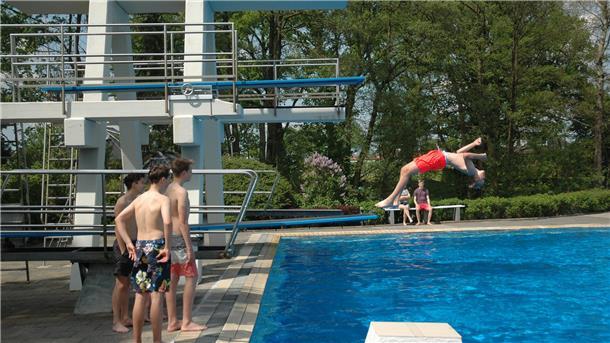 Das Foto zeigt Jugendliche beim Sprungturm. 