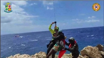 Das von der italienischen Bergwacht zur Verfügung gestellte Videostandbild zeigt eine Rettungsaktion in einer unwegsamen Bucht auf Lampedusa.