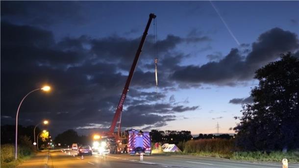 Sekundenschlaf: Nachtfahrt mit Wohnmobil in Cuxhaven endet in Graben Ein mobiler Kran steht am Rande einer Straße, davor ein Fahrzueg der Feuerwehr.