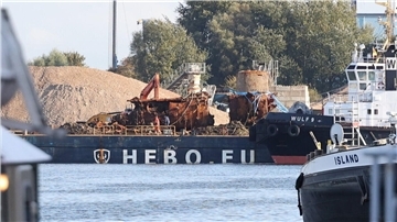 Das Wrack des U-Boots "U16" liegt im Hafen. Im Vordergrund sind mehrere Schiffe.