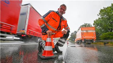Dauerregen bremst die Arbeiten an den Markierungsleuchtknöpfen auf der Grimsbystraße aus. Christian Kluge von der Firma Siemens zeigt ein noch unfertiges Element am Boden. 