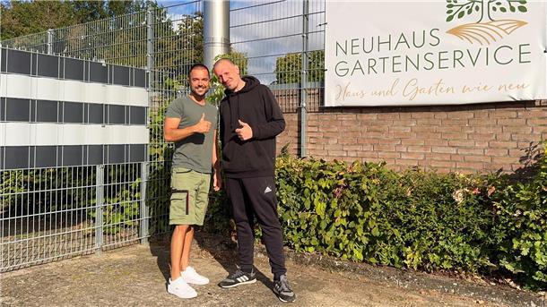 Zwei junge Herren stehen vor einem Gebäude, lächeln in die Kamera und halten einen Daumen nach oben.