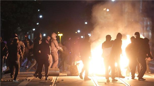 Demonstranten an einer brennenden Barrikade.