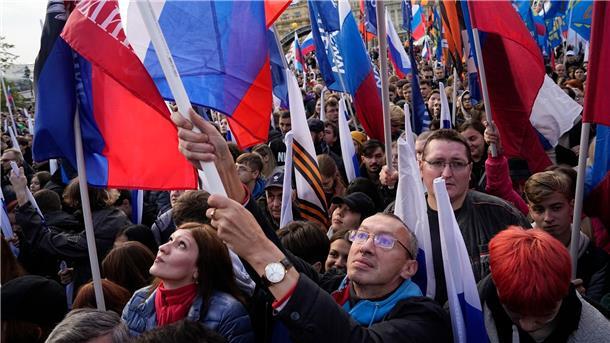 Demonstranten halten russische Fahnen zur Unterstützung der Scheinreferenden auf dem Manezhnaya-Platz in Moskau.