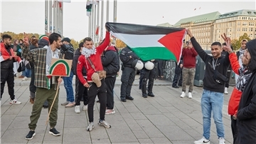 Demonstranten halten trotz eines Verbots einer Pro-Palästinenser-Demonstration am Flaggenplatz am Hamburger Jungfernstieg eine Palästina-Flagge hoch.