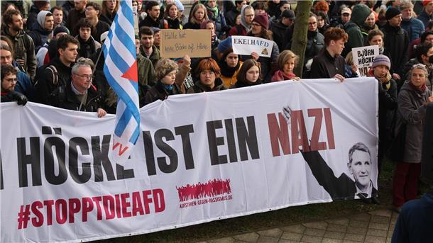 Demonstrantinnen und Demonstranten protestieren am Justizzentrum in Halle gegen Björn Höcke.