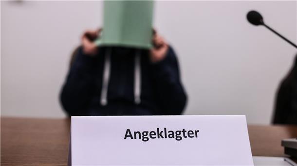 Babysitter und „Monster“: Missbrauchsprozess Wermelskirchen Der Angeklagte im Missbrauchskomplex Wermelskirchen hält sich im Gerichtssaal eine Mappe vor das Gesicht.