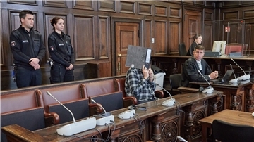 Der Angeklagte (mit Ordner vor dem Gesicht) sitzt im Gerichtssaal neben seinem Anwalt Robert A. Funk (r) kurz vor der Urteilsverkündung.