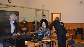 Der Angeklagte (sitzend, Mitte) sitzt aktuell in Untersuchungshaft in der JVA Bremervörde und wird zu Prozesstagen deshalb in Handschellen vorgeführt.