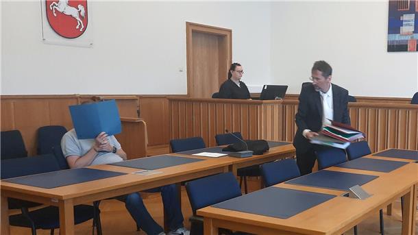Der Angeklagte verdeckt vor Gericht sein Gesicht.