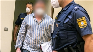 Der Angeklagte wird von der Polizei in den Gerichtssaal geführt.