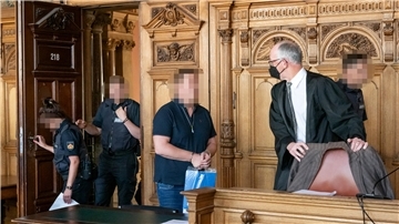 Der Angeklagte wird von Justizvollzugsbeamten in den Verhandlungssaal geführt.