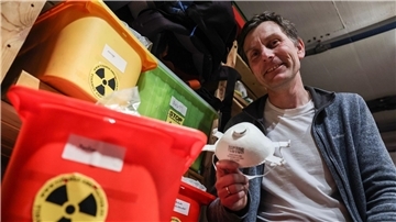 Der Anti-Atomkraft-Aktivist Gereon Hermens sitzt in seinem Keller neben Kisten mit Schutzausrüstungen.