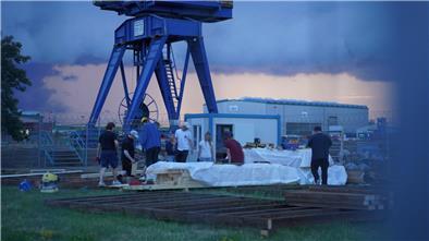 Der Aufbau des Festivalgeländes läuft auf Hochtouren: Viele junge Menschen helfen mit, Bühne, Bar und Sitzplattform am Neuen Hafen aufzubauen. 