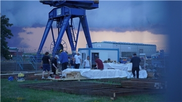 Der Aufbau des Festivalgeländes läuft auf Hochtouren: Viele junge Menschen helfen mit, Bühne, Bar und Sitzplattform am Neuen Hafen aufzubauen. 