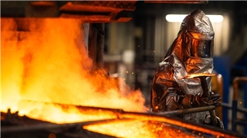 Ein Arbeiter in Schutzkleidung am Badschmelzofen der Bleihütte von Glencore in Nordenham.