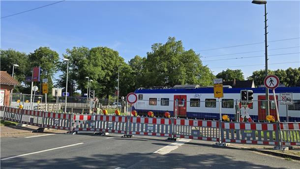 Ein Zug passiert einen Bahnübergang, der wegen Bauarbeiten für den übrigen Verkehr voll gesperrt ist.