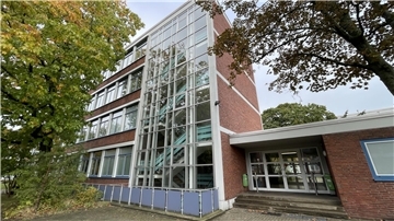 Eingang und Treppenhaus mit gläserner Front eines Schulgebäudes