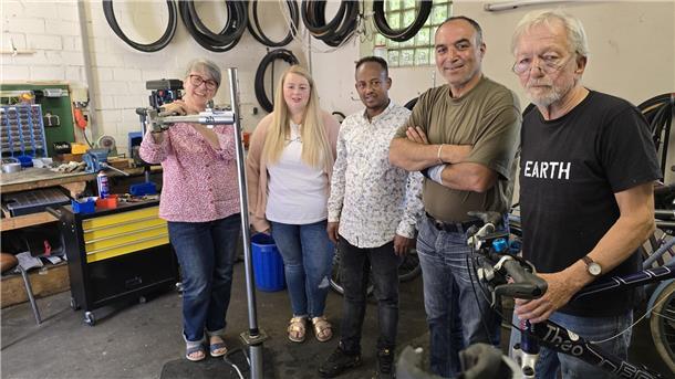 Zwei Frauen und drei Männer in einer Fahrradwerkstatt