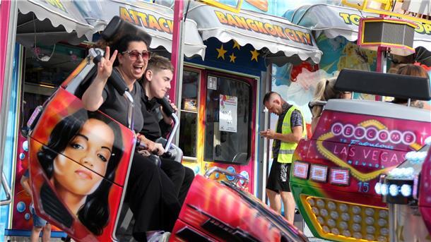 Zwei Menschen in einem Fahrgeschäft auf dem Freimarkt. 