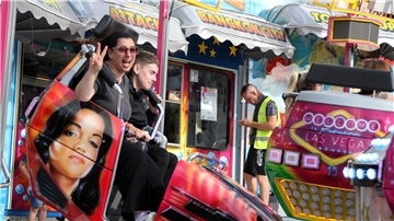 Zwei Menschen in einem Fahrgeschäft auf dem Freimarkt. 