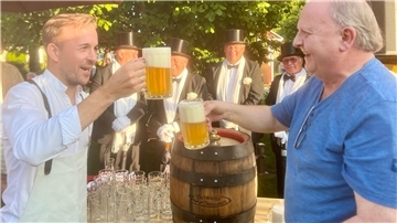 Der CDU-Bundestagsabgeordnete Bastian Ernst prostet Andreas Christiani, Braumeister im "Butjadinger Tor", mit einem Glas Bier zu