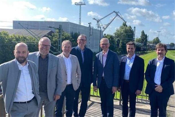 Darum fordert Björn Thümler (CDU) mehr Geld für private Hafenbetreiber Das Foto zeigt sieben Männer, die in Nordenham vor dem dortigen Midgardhafen stehen.