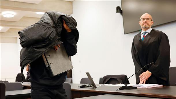 Vergewaltigungen in Asylheim: Haft für Ex-Security-Mann Der ehemalige Security-Mann bedeckt im Gerichtsaal seinen Kopf mit einer Jacke.