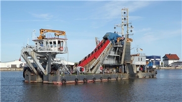 Der Eimerkettenbagger „Bremerhaven“ schwimmt im Hafenbecken.