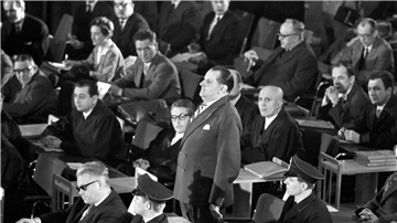 Der erste Auschwitz-Prozess im Plenarsaal der Frankfurter Stadtverordnetenversammlung wird eröffnet. In der ersten Reihe sitzt der Angeklagte Victor Capesius (mit dunkler Brille), hinter ihm steht der Angeklagte Oswald Kaduk. (zu dpa: „Als die Täter von Auschwitz in Frankfurt vor Gericht kamen“)