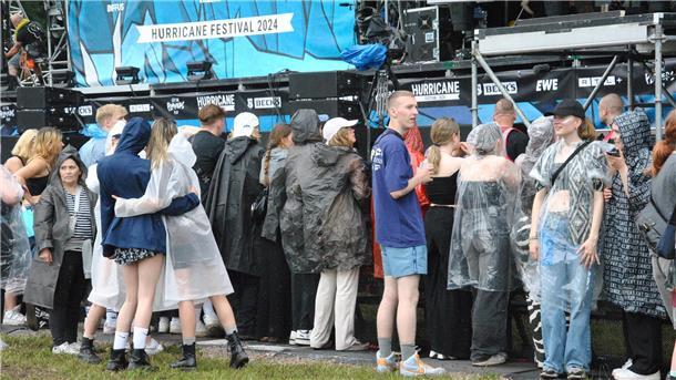 Der erste Regen fällt aufs Festivalgelände. Schnell schnappen sich die Besucher ihre Regenponchos.