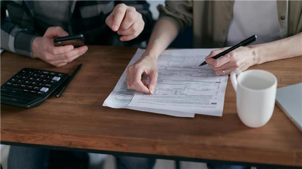 Geld und Beziehung: Wie junge Paare gemeinsame Finanzpläne entwickeln Person schreibt auf Zettel