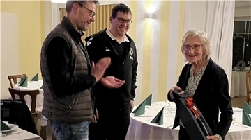 Der erste Vorsitzende Christian Bäron und der zweite Vorsitzende Marc Pape überreichen Berta Schröder ein Präsent für 70 Jahre Mitgliedschaft.