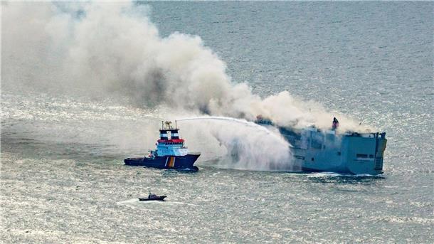 Auto-Frachter brennt vor Küste - Umweltkatastrophe droht  Der Frachter „Fremantle Highway“ steht in Flammen. Ein Notschlepper (l) bekämpft das Feuer.