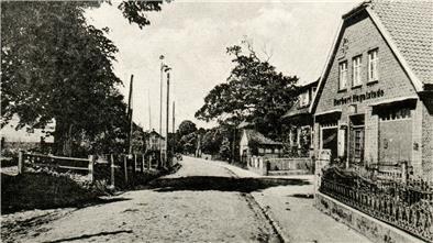 Kopfsteinpflasterstraße mit Geschäftshaus auf der rechten Seite