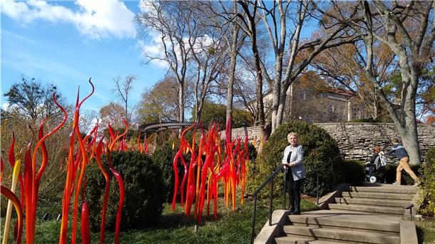 Sie trotzen Covid mit Kunst und der Ruhe am Strand  Renate Stone  steht auf dem auf dem Gelände des Cheekwood-Herrenhauses neben einer roten Glasskulptur des Künstlers Dale Chihuly.