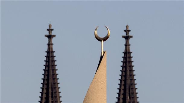 Taliban-Auftritt in Kölner Moschee sorgt für Empörung Der Halbmond auf einer Moschee ist zwischen den Türmen des Kölner Doms zu sehen. Der Auftritt eines hochrangigen afghanischen Taliban-Funktionärs in einer Kölner Moschee löst harsche Kritik aus.