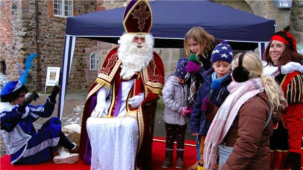 Der heilige Nikolaus, in den Niederlanden Sinterklaas, lauscht einem plattdeutschen Gedicht der Kinder aus Badenstedt.