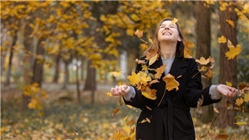 Eine Frau mit Herbstblättern.